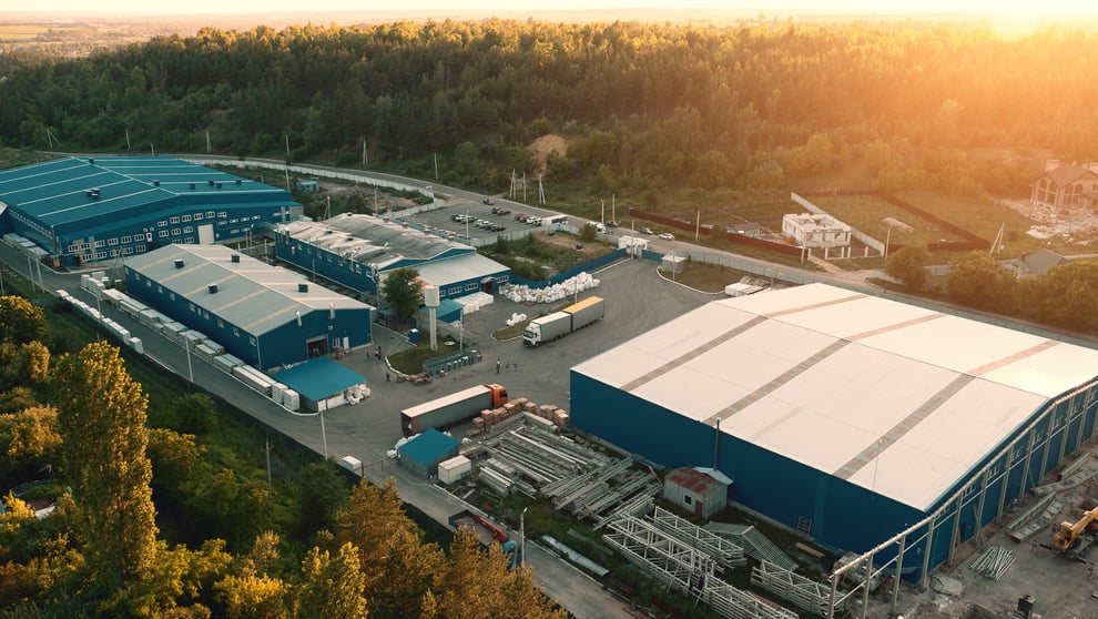 Aerial view of warehouse storages or industrial factory or logistics center from above. Aerial view of industrial buildings at sunset